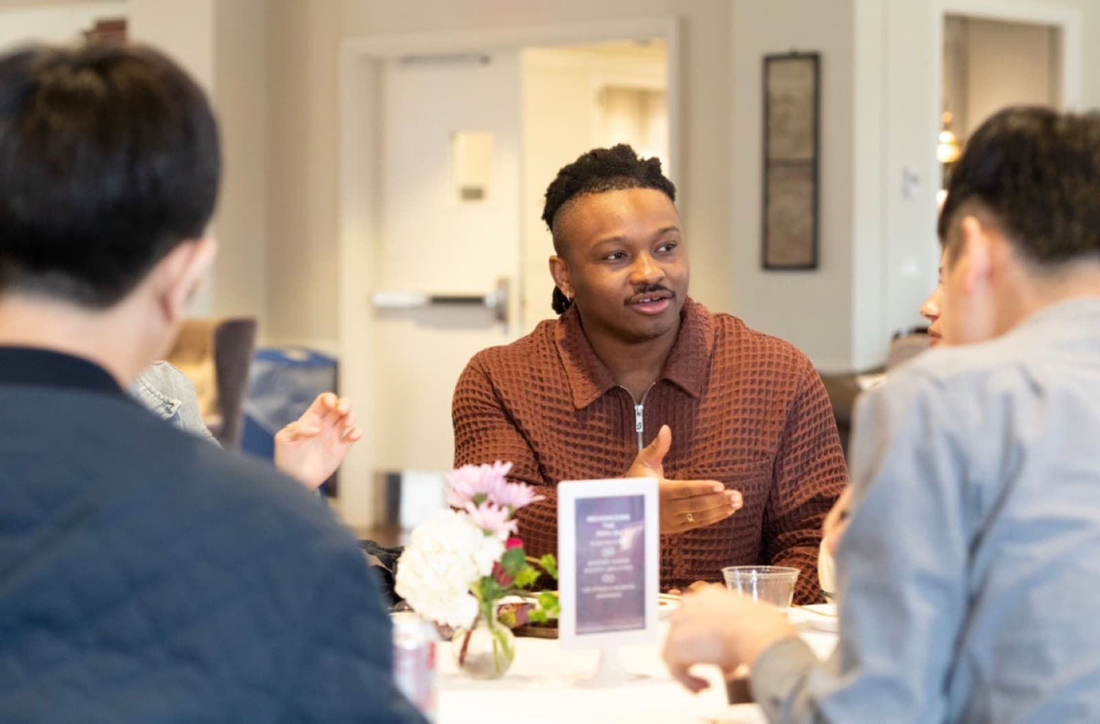Jonathan Doriscar in conversation at a table, gesturing while advising on a research question.