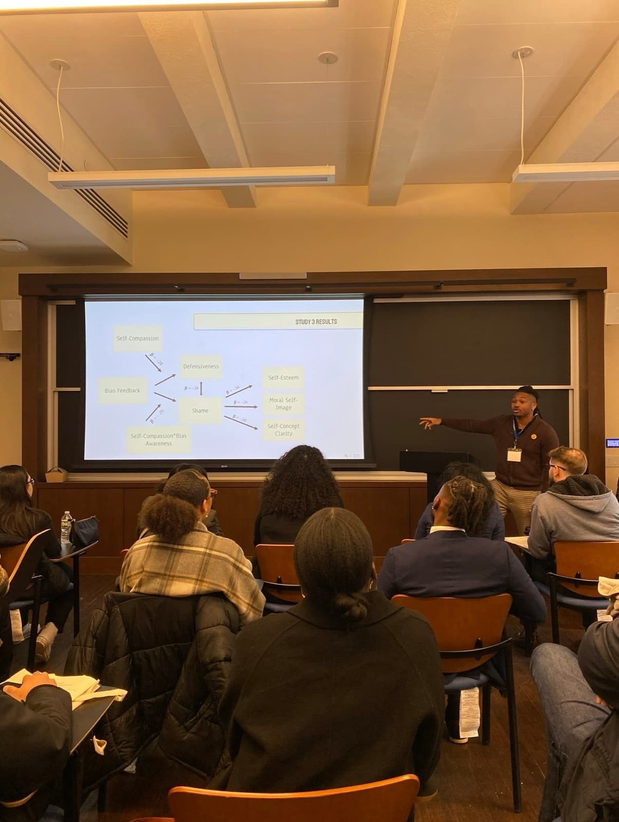 Jonathan Doriscar teaching with a path diagram of study results projected behind him.